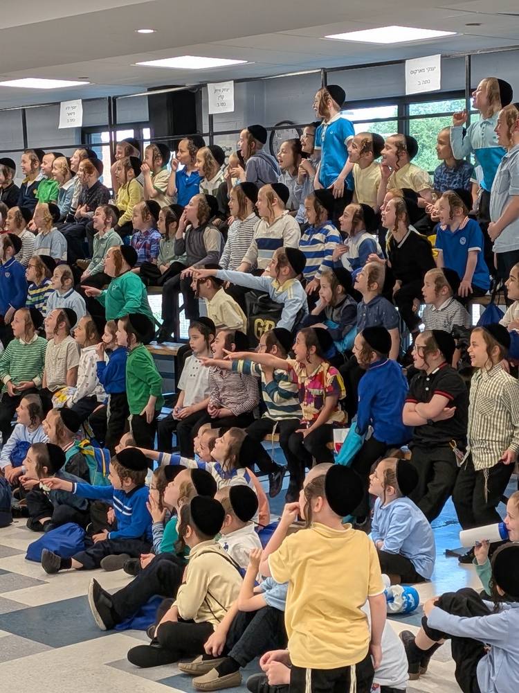 A packed room of boys watching the stage