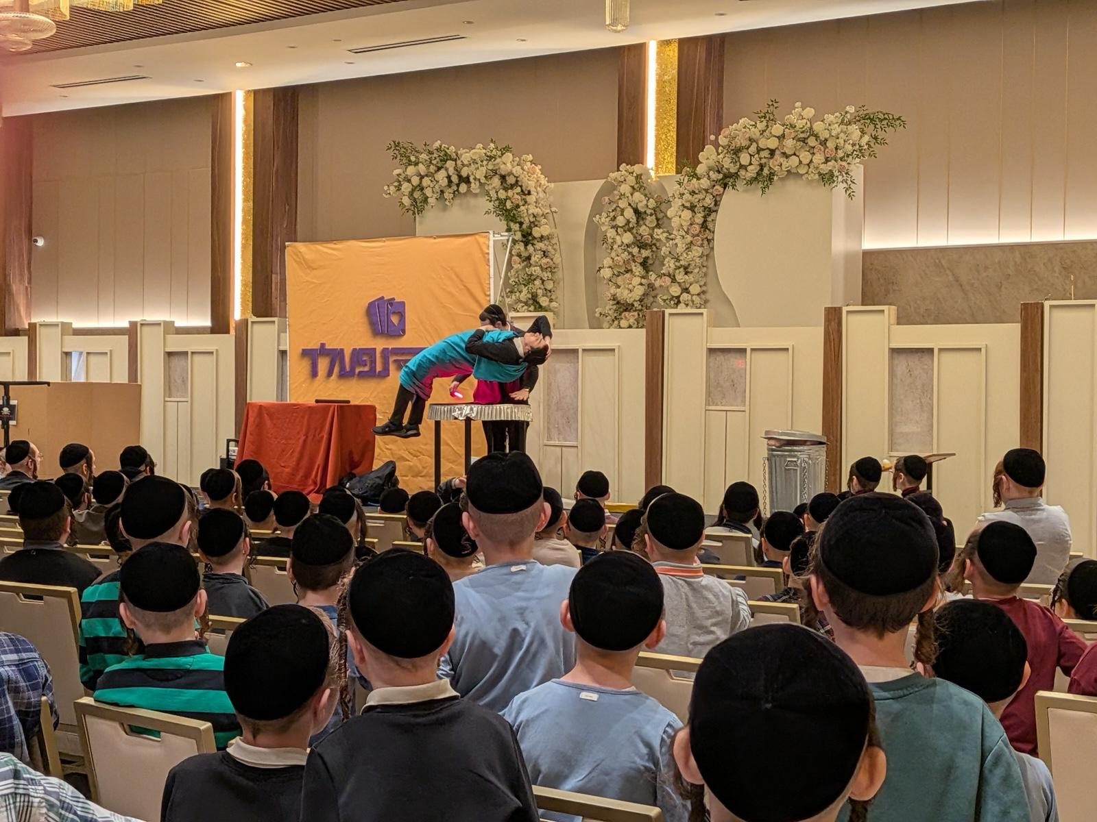 A stunt on stage in a full ballroom